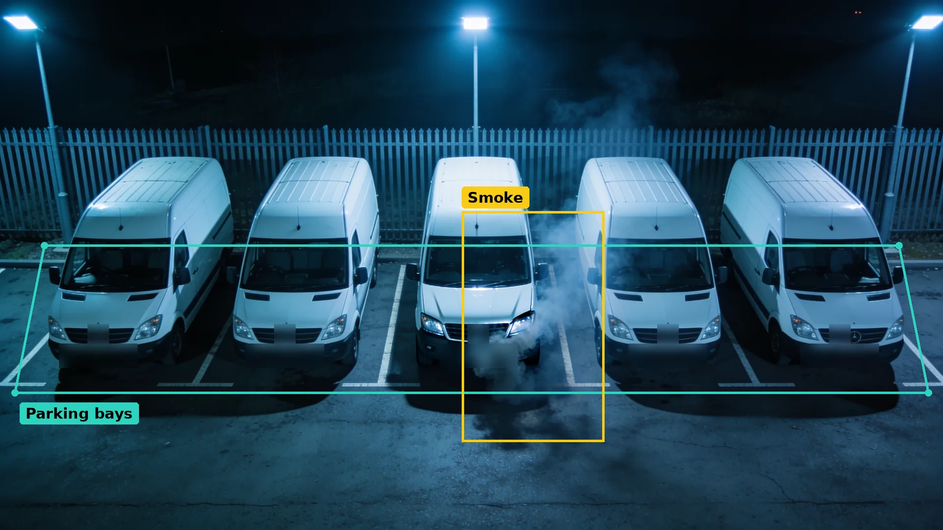 Night CCTV of five white vans in parking bays marked by a teal zone, smoke from the middle van boxed in amber
