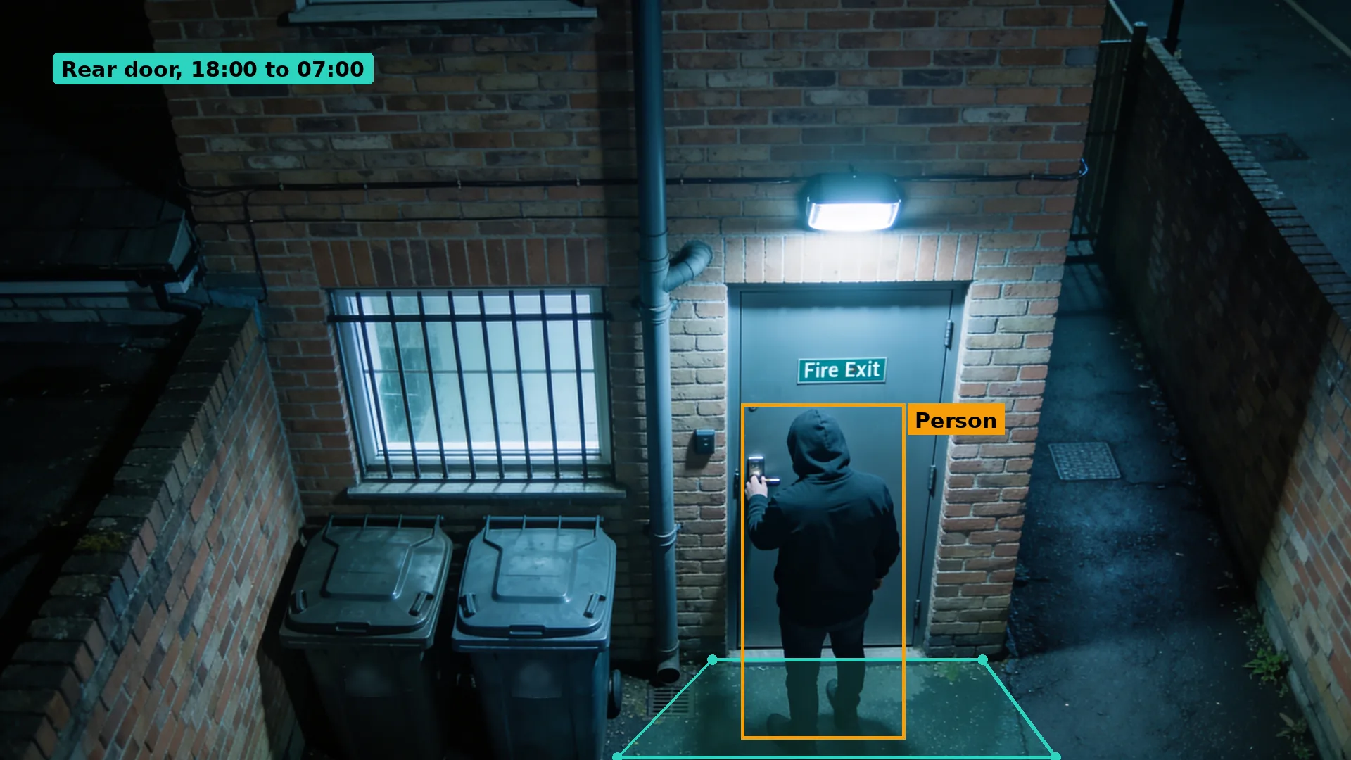 Night CCTV of a hooded person trying the handle of a rear fire exit door beside a barred window, boxed in amber