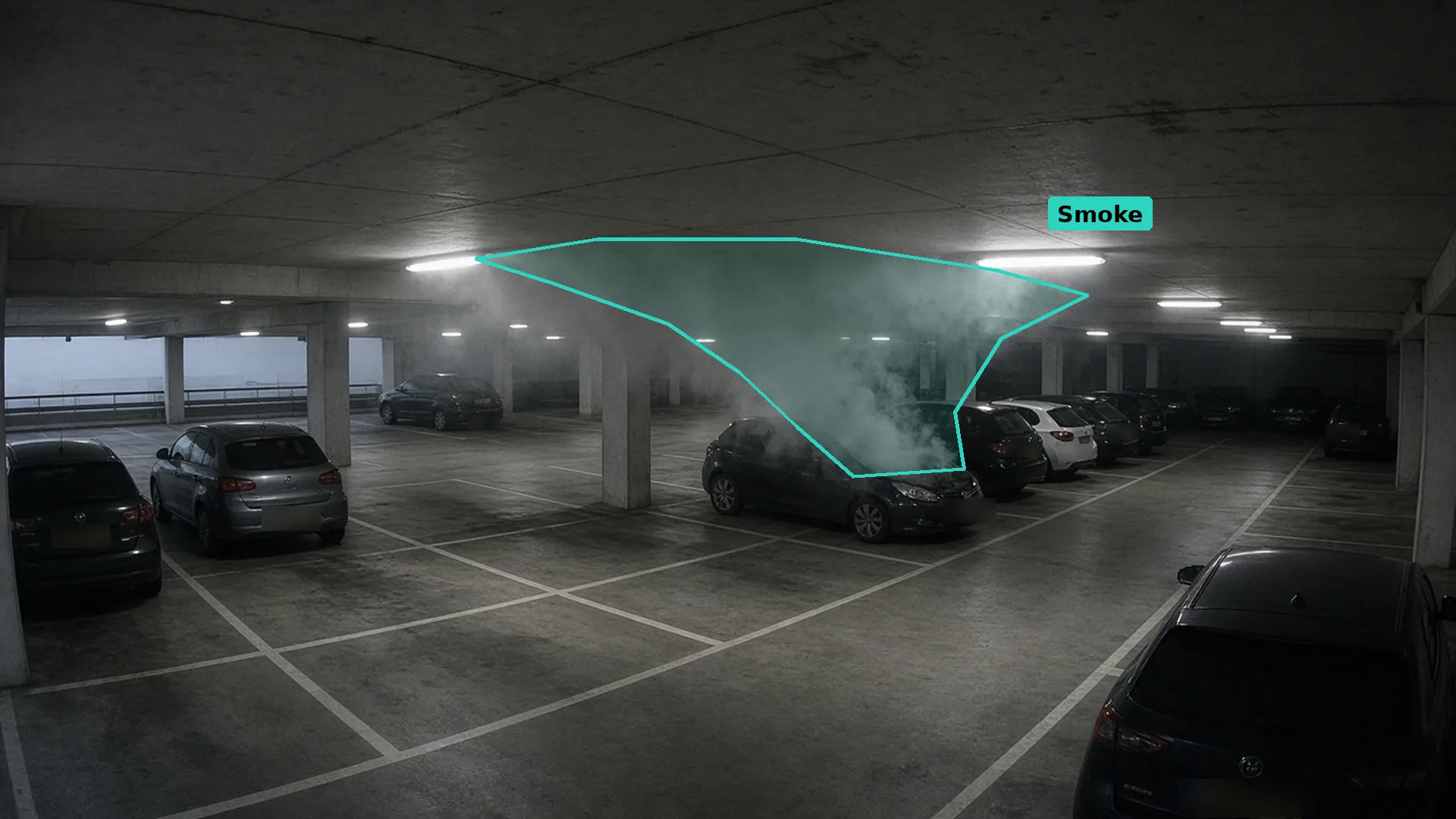 CCTV of grey smoke rising from under the bonnet of a parked car on a covered car park deck, the smoke outlined in teal