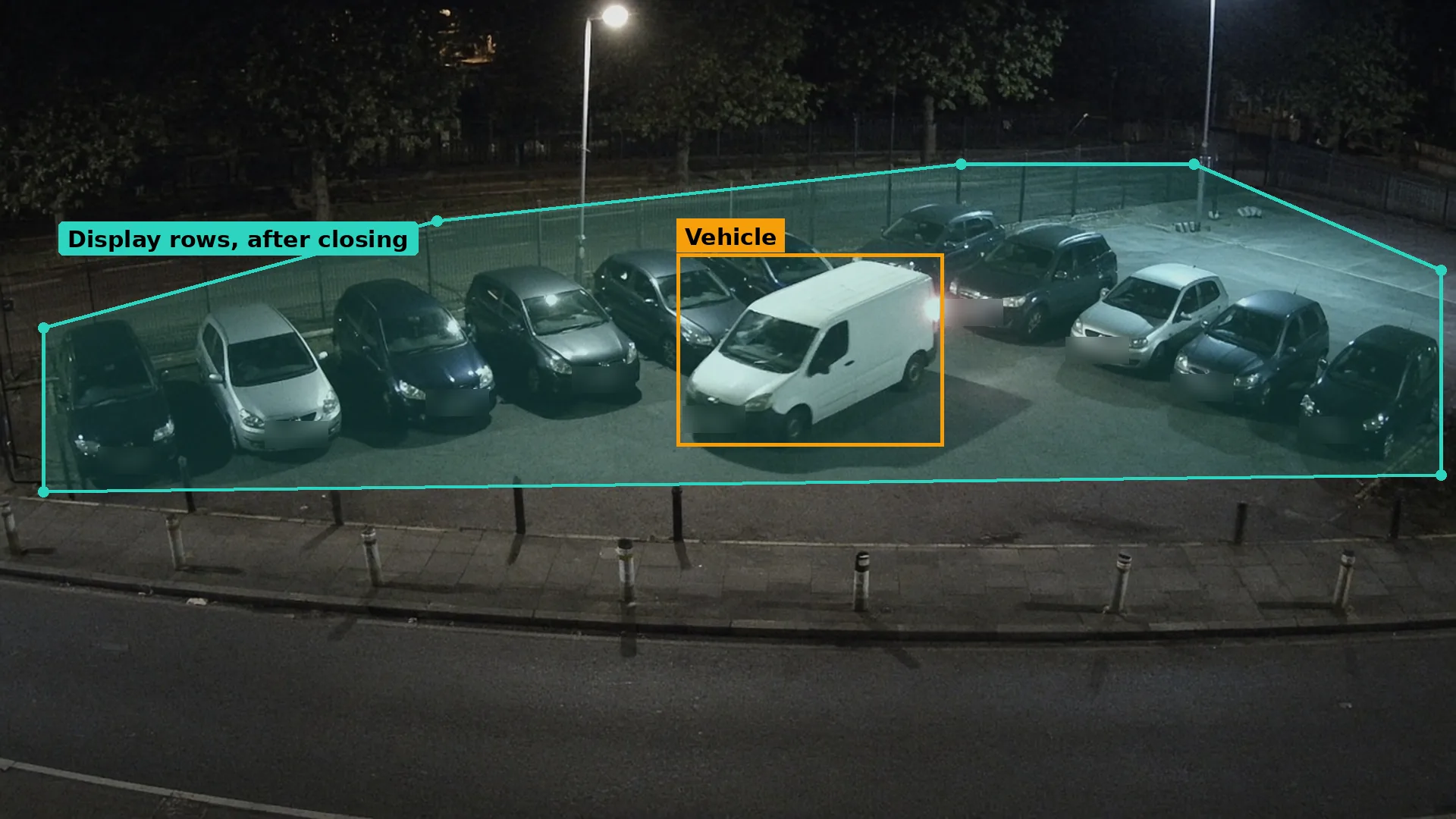 Night CCTV of a white van among parked cars on a roadside used car lot after closing, a teal zone, the van boxed