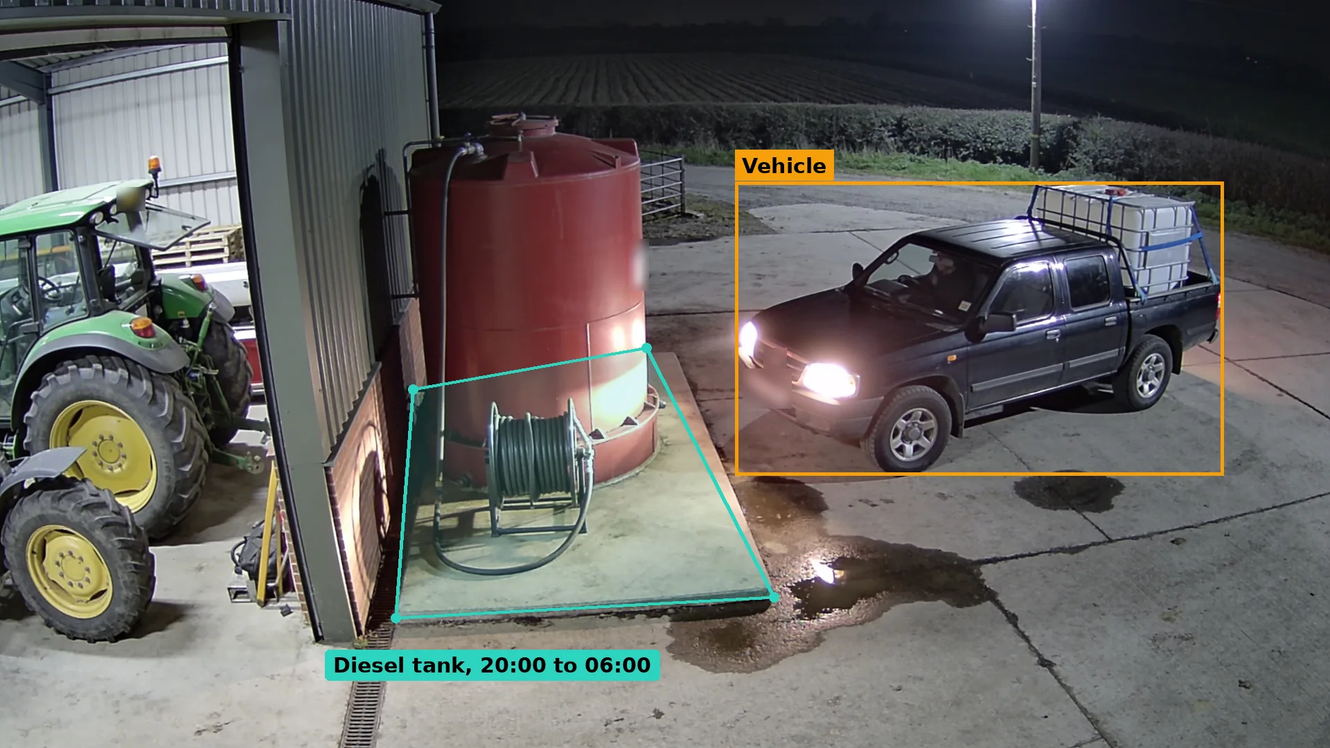 Night CCTV of a dark pickup with an empty IBC in the back parked beside a red farm fuel tank and hose reel