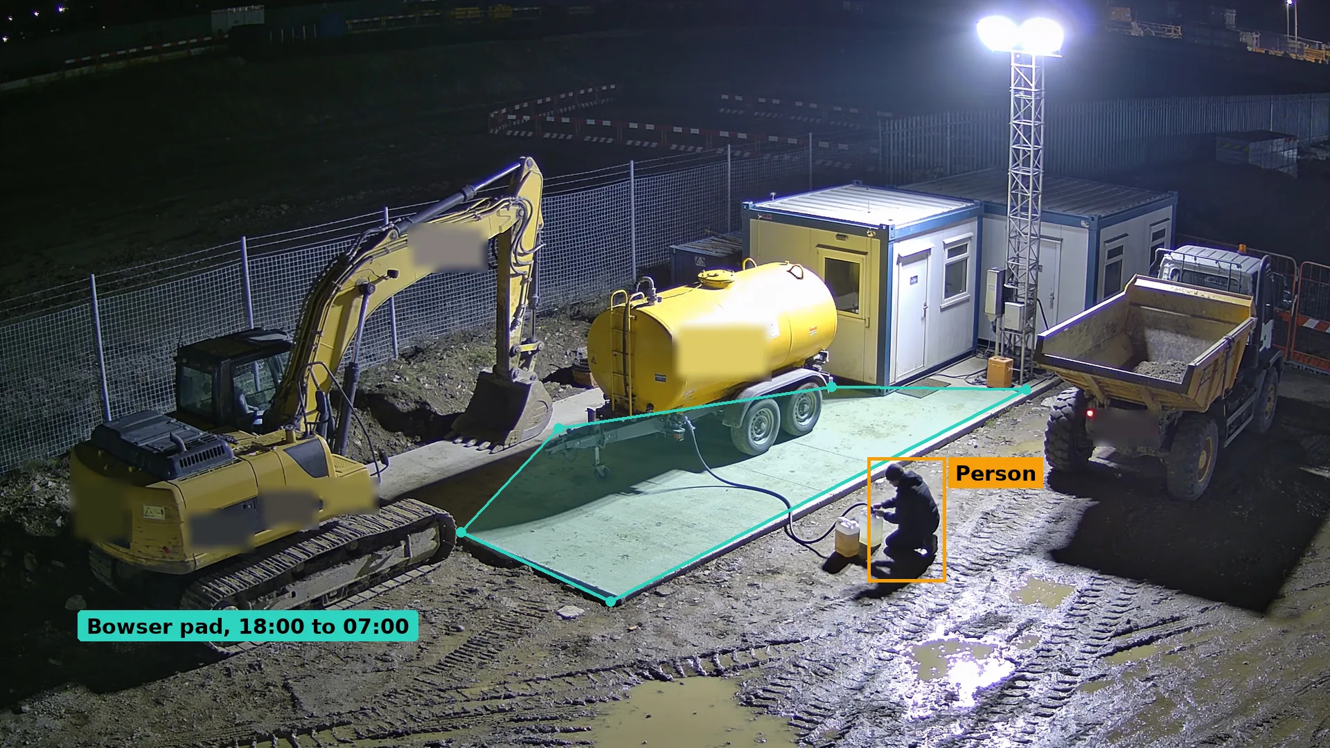 Night CCTV of a person crouching with a hose and a container beside a yellow diesel bowser on a building site