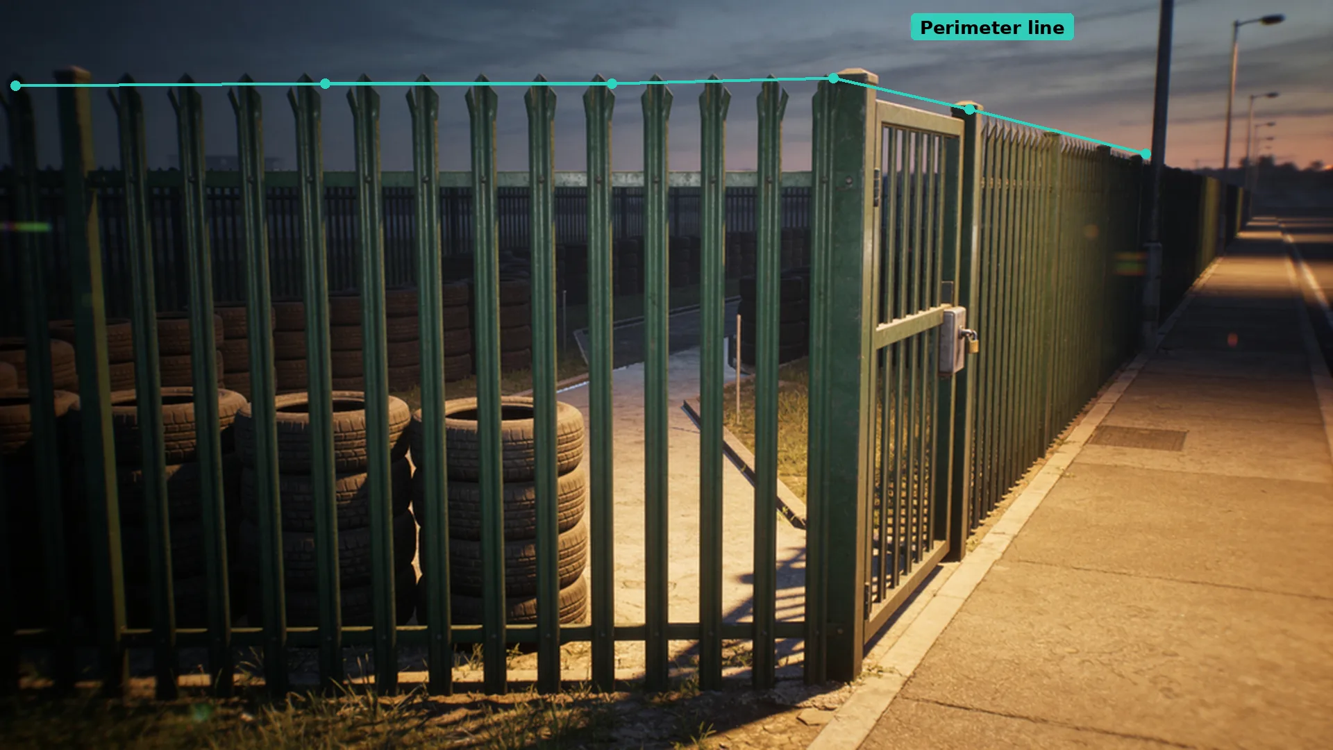 Dusk CCTV of a palisade fence and locked gate at a tyre yard, with a teal virtual line running along the post tops