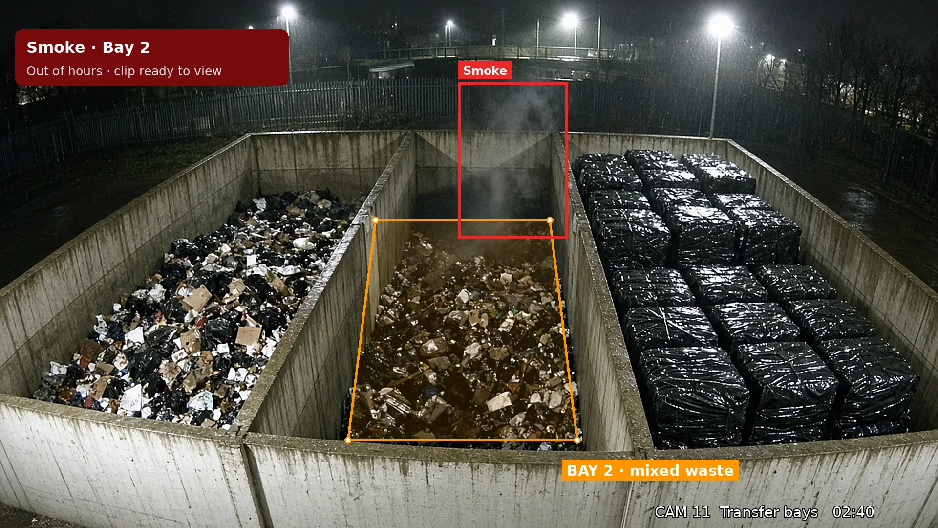 Night CCTV view: smoke rising from a mixed waste bay at a transfer station