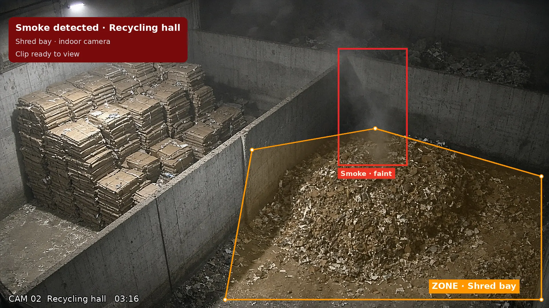 CCTV view: faint smoke rising from a shred pile in a dusty recycling hall, boxed as a smoke detection