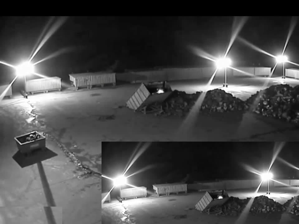 Night-time infrared CCTV view of a storage yard where Woodcock AI detected an early fire in a skip